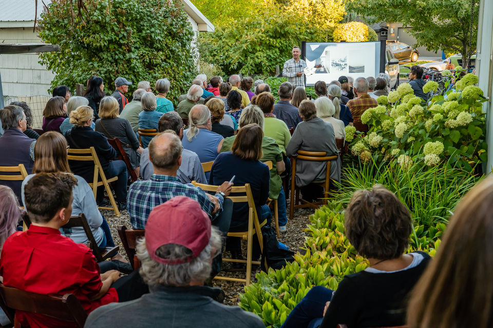 People fill the grounds at Surel's Place to see a presentation by a visiting artist.
