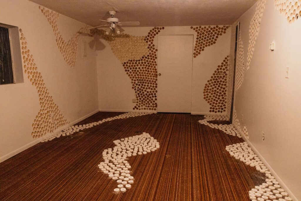An installation piece called "accretion" by David Beams. In the piece, holes are drilled out of the wall of a soon-to-be demolished space, and the holes themselved have been reattached elsewhere in the space.