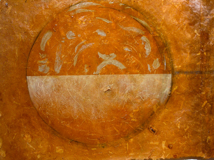 Detail view of artwork by Surel Mitchell with honey colors with shellac and paint on paper in the shape of a circle with half the circle delineated with lighter colored paint.